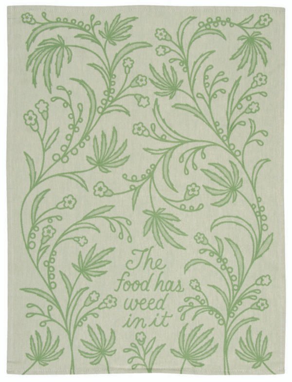 tea towel design in bright green tones, a floral background and cursive writing that says "the food has weed in it"